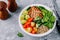 Healthy buddha bowl lunch with grilled chicken, quinoa, spinach, avocado, brussels sprouts, tomatoes, cucumbers on dark grey back