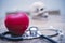 Healthy care concept. Red heart and stethoscope on wood table with blurred skull on wall background.  Picture for add text message