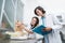 Healthy cat on a scale being held and weighed by two veterinarians