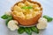 Healthy cauliflower pie on the gray plate decorated with fresh basil leaves. Vegetarian cauliflower tart on the gray background