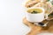 Healthy chicken soup with dill in a white bowl on a wooden cutting board with metal spoon and yellow kitchen towel