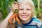 Healthy child in garden holding an unusual homegrown carrot