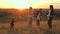 Healthy children and mom play, blow kid catches soap bubbles. mother and sisters play together in the park at sunset