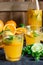 Healthy citrus lemonade from oranges fresh mint lime in glasses and bottle on dark stone kitchen table