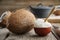 Healthy coconut oil for cooking in ceramic bowl and coconuts on kitchen table