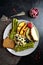 Healthy and completely vegan-friendly breakfast plate with hummus, asparagus, fruit, and protein bread