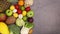 Healthy composition of fresh ripe fruits and vegetables appear on left side of dark background. Stop motion