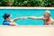 Healthy couple elder happy playing together at swimming pool, enjoy fun summer vacation life after Covid-19