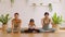 Healthy couple mom and little girl doing yoga child pose on yoga mat with yoga instuctor at home.Private yoga class coaching child