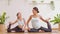 Healthy couple mom and little girl doing yoga swan pose on yoga mat at home.Female mother and daughter practice yoga breathing