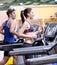 Healthy couple on a treadmill in a sport center