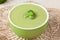 Healthy cream broccoli soup meal in a green bowl