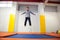 Healthy cute little boy jumping on trampoline indoors in sport centre