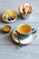 Healthy dessert: pieces of candied pineapple, ginger root, dried figs, apple chips and honey in small bowls and a cup of green tea