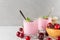 Healthy diet breakfast. Cherry yogurt in glasses with fresh berries, oats and mint on white marble table