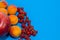 Healthy diet composition,  raspberries, apricots, apple and red currants on blue background