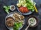 Healthy diet lunch - grilled chicken fillet, rye seed bun, fresh tomatoes, lettuce, avocado and yogurt mustard sauce on dark