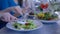 Healthy diet lunch, hands closeup eating vegetable useful salad from plate during food time in restaurant