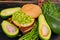 Healthy diet Mexican guacamole burger on the wooden board decorated with fresh dill. Vegetarian green sandwich on the black table