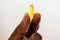 Healthy Diet Nutrition. Young Black Woman Holding Fish Oil Pill In Hand and fingers, Capsule With Cod Liver Oil, Omega-3. Vitamin