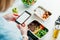 Healthy diet plan for weight loss, daily ready meal menu. Woman using phone with blank screen for app while weighing