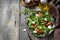 Healthy diet salad with arugula, mozzarella, mussels and vinaigrette dressing on a wooden table. Low calories keto dieting meal.