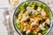 Healthy diet salad with chicken, mushrooms, carrots, celery, olives, cheese and lettuce close-up in a bowl. Horizontal top view