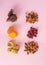 Healthy dried fruits: almonds, figs, raisins, cranberries, dates and apricots on a pastel pink background. Flat lay minimal arrang