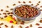 Healthy dry cat food. Brown crunchy organic kitty kibble pieces in a bowl for pet feed and mouse toys on light background.
