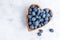 Healthy eating antioxidant blueberries in a wooden bowl heart shaped top view