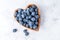 Healthy eating antioxidant blueberries in a wooden bowl heart shaped top view