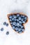 Healthy eating antioxidant blueberries in a wooden bowl heart shaped top view