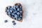 Healthy eating antioxidant blueberries in a wooden bowl heart shaped top view