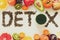 Healthy eating concept. Word `detox` from green tea with colorful smoothies and fruits.