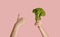 Healthy eating and dieting. Young girl holding broccoli and showing thumb up gesture on pink background, panorama