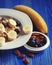 Healthy eating, food and diet concept - oatmeal with berries, nuts and bananas, white plate, blue wooden background.