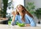 Healthy eating. happy young girl eating salad in morning in kitchen