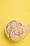 Healthy eating. Oat flakes. Wooden spoon. Yellow background