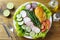 Healthy eating plate of grilled chicken breast and vegetable salad over rustic wooden table. Ketogenic and Paleolithic Diet