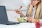 Healthy eating at work. Woman indulges in a delightful fresh salad at her workplace. With every bite, she embraces the nourishing