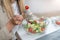 Healthy eating at work. Woman indulges in a delightful fresh salad at her workplace. With every bite, she embraces the nourishing