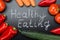 Healthy Eating Written Amidst Vegetables On Blackboard