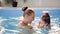 Healthy family mother teaching baby swimming pool