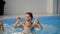 Healthy family mother teaching baby swimming pool