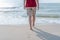 Healthy female legs with droplets walking to leave footprints barefoot alone on sandy sea beach in summer
