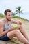 Healthy fit man eating organic vegan food on beach