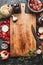 Healthy food background with aged cutting board, cooking pot ,vegetables and kitchen knife, top view