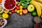 Healthy food background, trendy Alkaline diet products - fruits, vegetables, cereals, nuts, oils, dark grey concrete background.