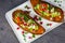 Healthy food - Baked sweet potatoes served with guacamole, feta cheese and pomegranate