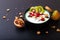 Healthy food colorful Yogurt Breakfast Bowl with kiwi, flax seeds, Granola, and red currants in black ceramic bowl with copy